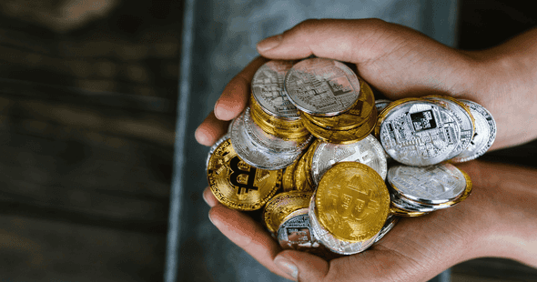 holding a stack of Bitcoin and Ethereum tokens. A person holding a stack of cryptocurrency.